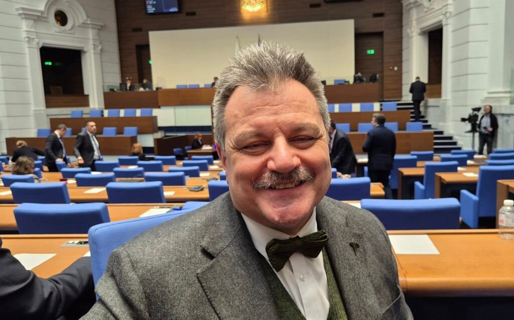 Снимка на д-р Александър Симидчиев на фона на пленарната зала на Народното събрание