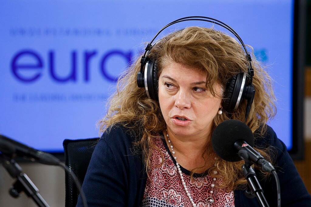 Илияна Йотова по време на радиоинтервю със слушалки и микрофон в студио.