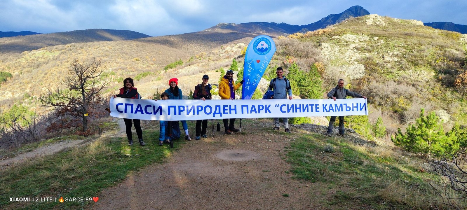 Граждани с транспарант „Спаси природен парк „Сините камъни“ по време на поход в планински район край Сливен.