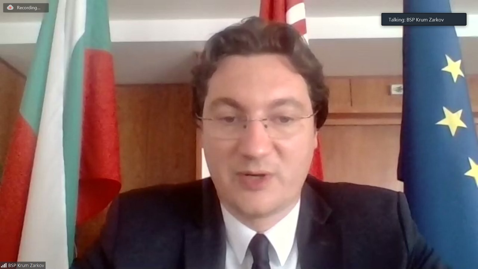 Крум Зарков по време на онлайн изявление, с българското и европейското знаме зад него